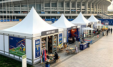 Carpas modulares tipo pagoda con mostradores de venta al público en el exterior de un estadio